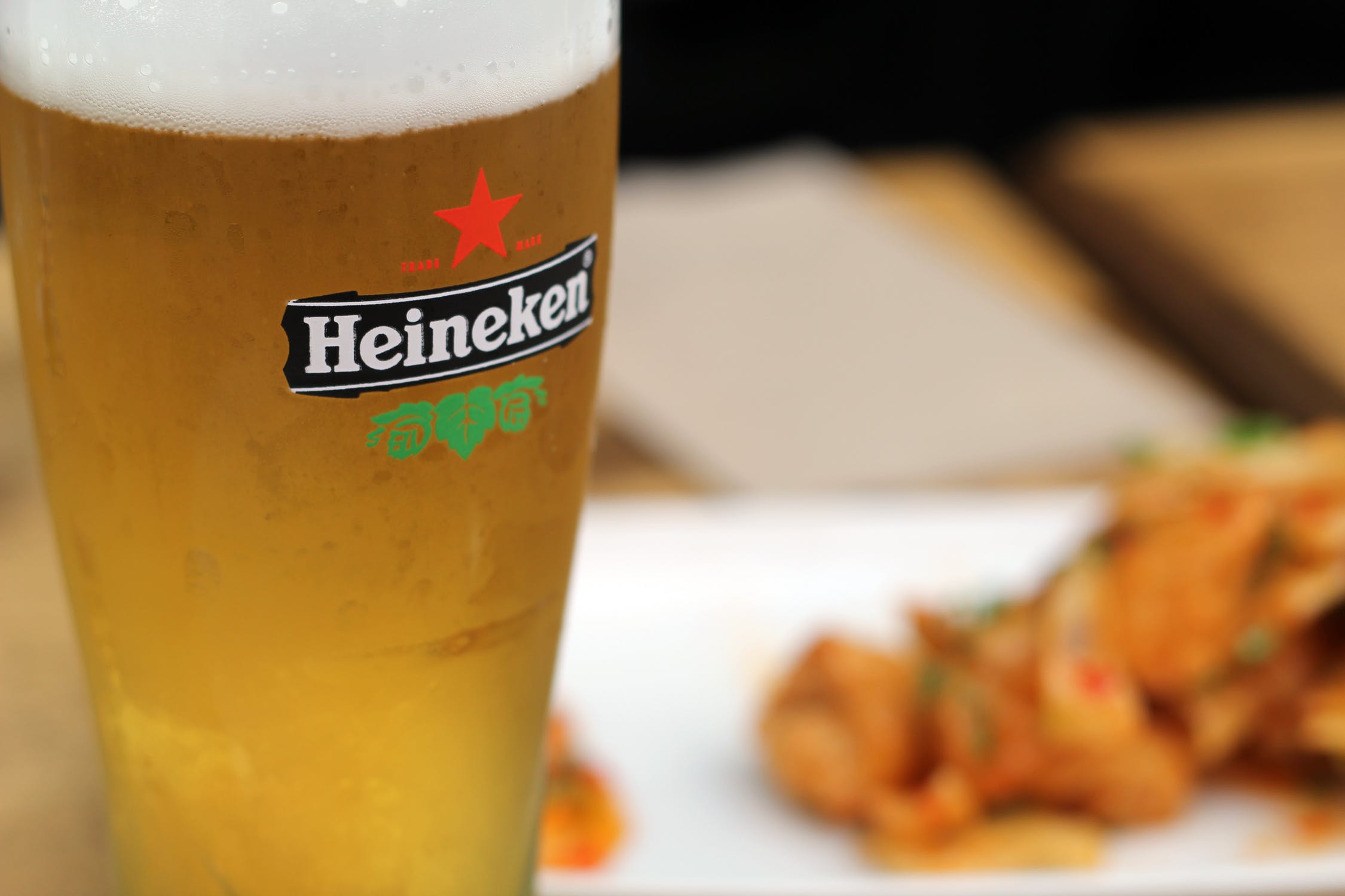 A chilled beer glass next to a meal on a plate.