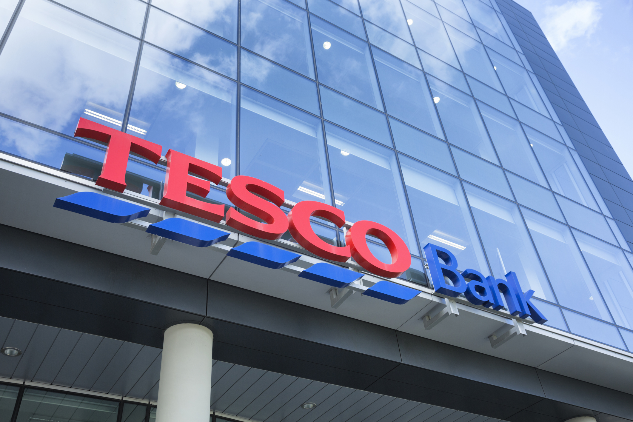 The outside of a bank building, looking up at the sign above the main entrance.